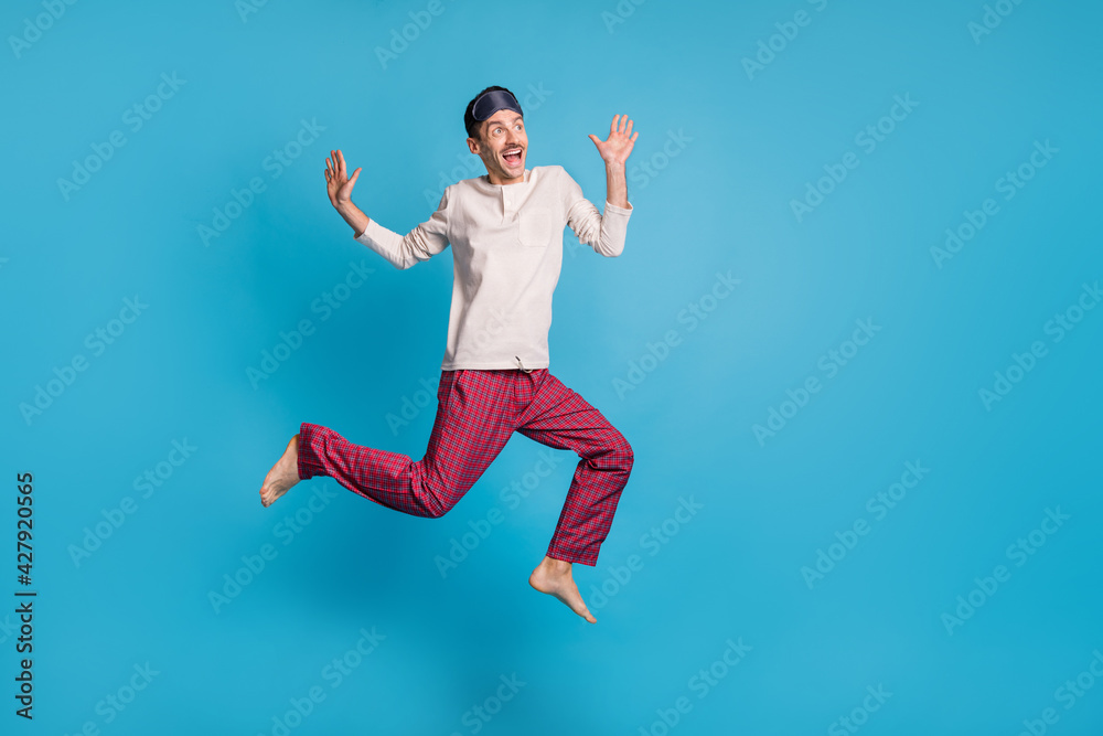 Fototapeta premium Full length photo portrait of dreamy man screaming jumping up looking at blank space isolated on vivid blue colored background
