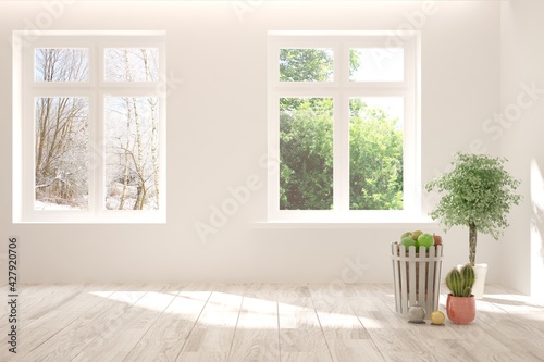 Fototapeta Naklejka Na Ścianę i Meble -  White empty room with summer and winter landscape in window. Scandinavian interior design. 3D illustration