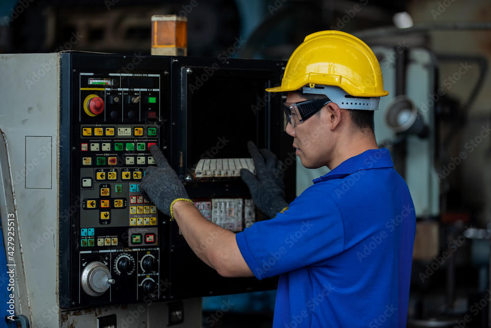 workers are standing using  machine in industrial plant.