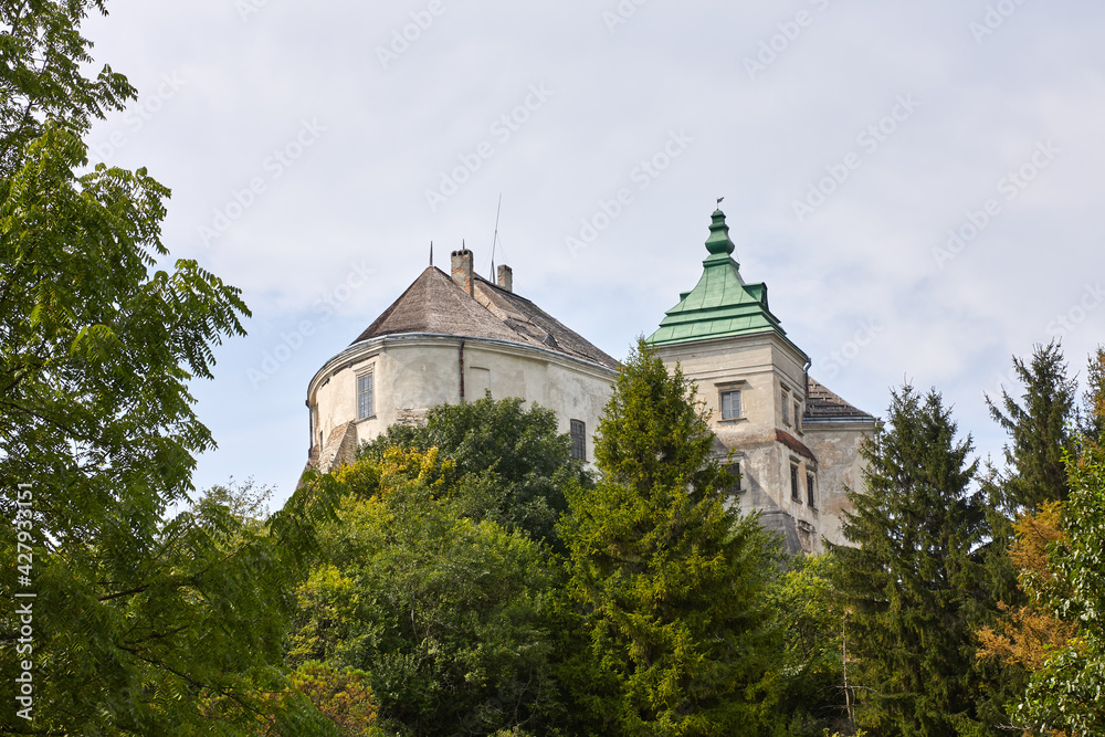Undefined castle in East Europe. Beautiful stronghold against blue sky in forest