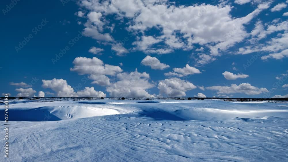 winter snowbound hills under a cloudy sky, seasonal time lapse scene