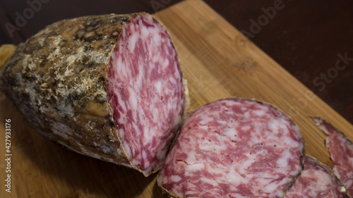 closeup of italian sopressa salami with homemade bread with knife and being cut photo