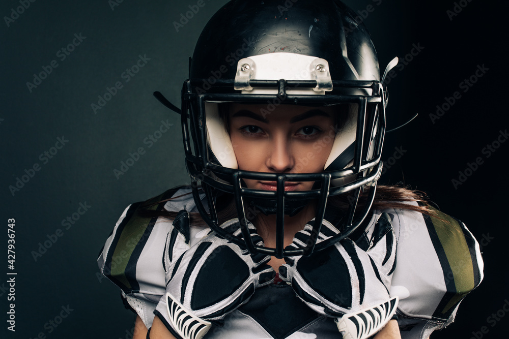 Portrait of young woman in American football uniform and helmet. Portrait of young woman in American football uniform and helmet.
