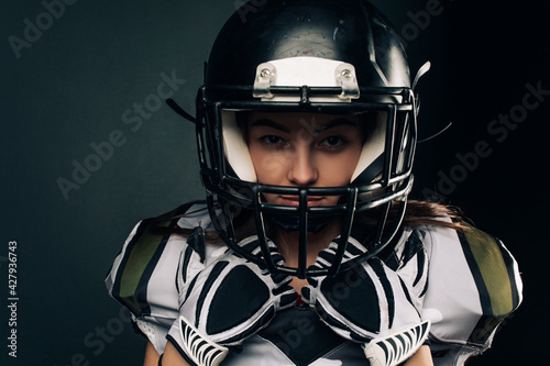 Portrait of young woman in American football uniform and helmet. © Stanislav