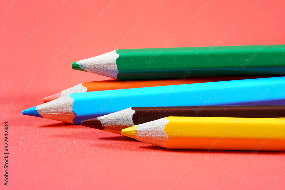 Colorful crayons, pencils with plain paper as a background with structure Colorful crayons, pencils with plain paper as a background with structure