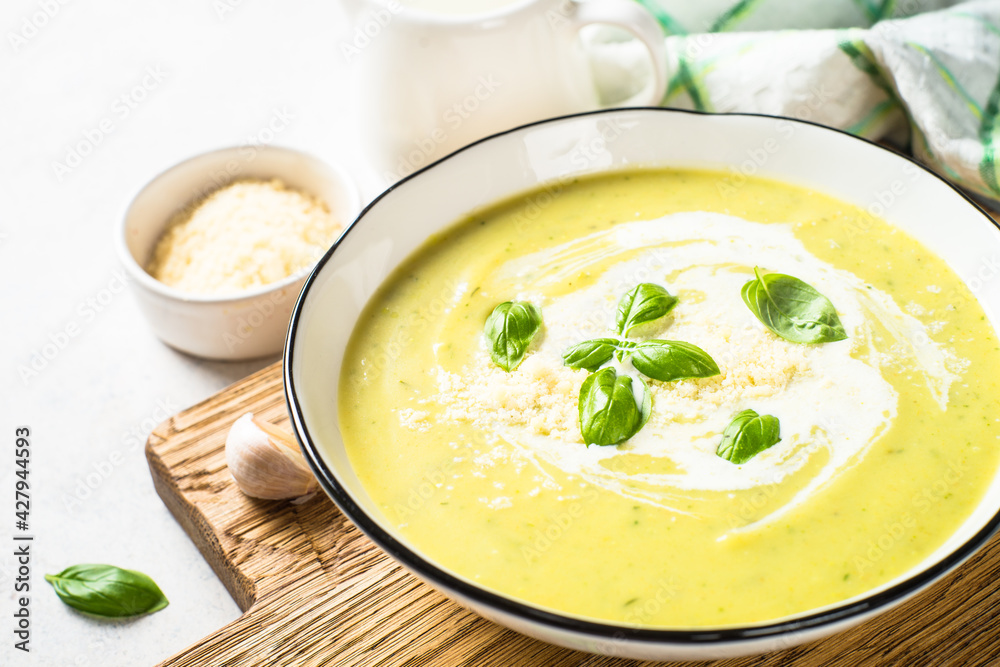 Zucchini soup with spinach and herbs at white.