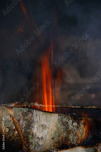 One close-up of a flame bursting out of a bonfire