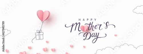 Mother's day postcard with paper flying elements and gift box on white sky background. Vector symbols of love in shape of heart for greeting card design photo