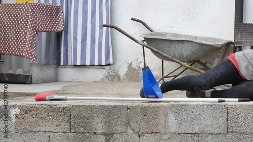 accidents while cleaning domestic house where a caucasian girl falls off the ladder with broom and dustpan and bucket of water
