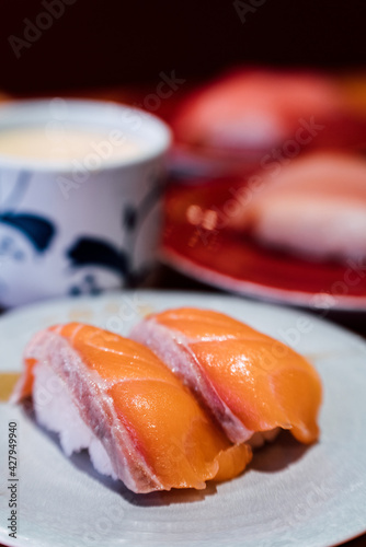 Sushi and Sashimi. Dishes of Sushi and Sashimi rolling on conveyer belt. photo