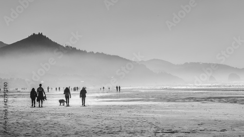 Gente caminando en una playa con neblina