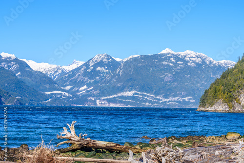 Fantastic view over ocean, snow mountain and rocks at Furry Creek Dive Site in Vancouver, Canada.
