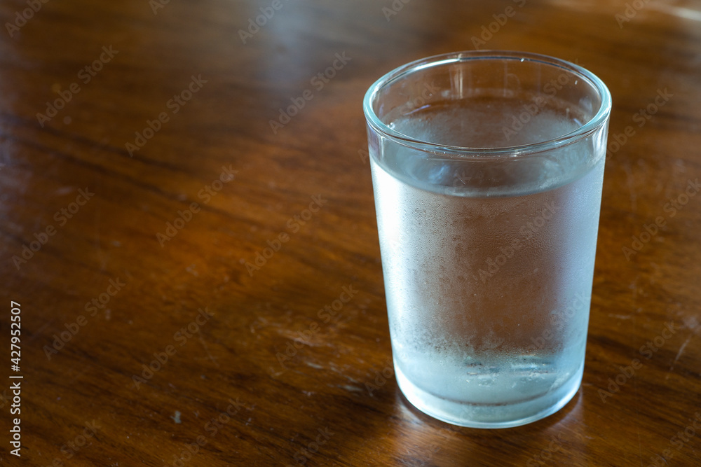 A glass of cool drinking water on a wooden table. A glass of cool drinking water on a wooden table.