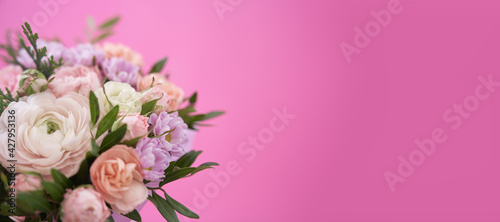 Beautiful bouquet of mixed different flowers in hand on pink background banner with copy space, greeting, gift © daryakomarova