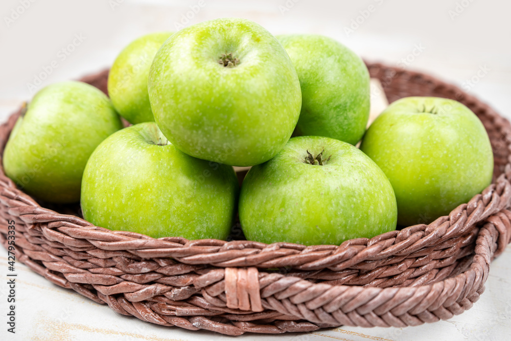 Group of ripe green apples in a basket on white background Group of ripe green apples in a basket on white background
