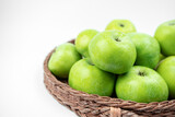 Group of ripe green apples in a basket on white background