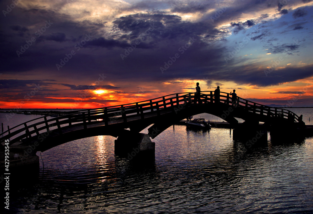 LEFKADA ISLAND, IONIAN SEA, GREECE. Sunset view by the wooden bridge at the small marina for fishing boats in Lefkada town.