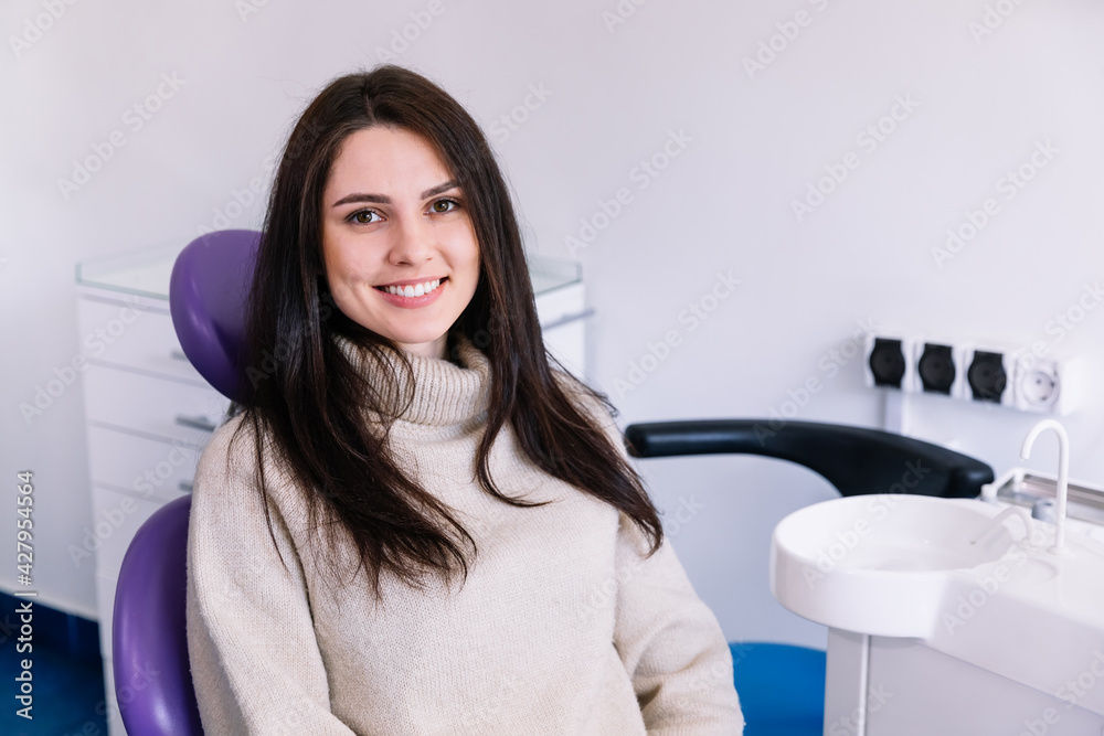 young woman with a wide white smile in a sweater looking at the young woman with a wide white smile in a sweater looking at the