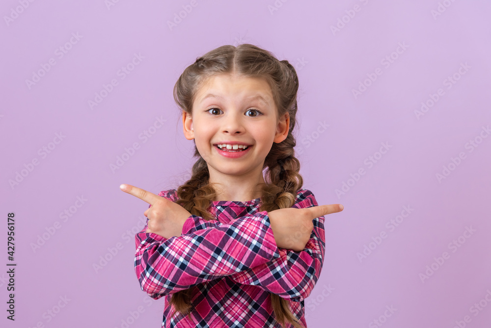 A child with braids on his head points his fingers in different directions. A child with braids on his head points his fingers in different directions.