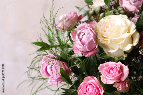 Beautiful bouquet with roses on beige background  closeup