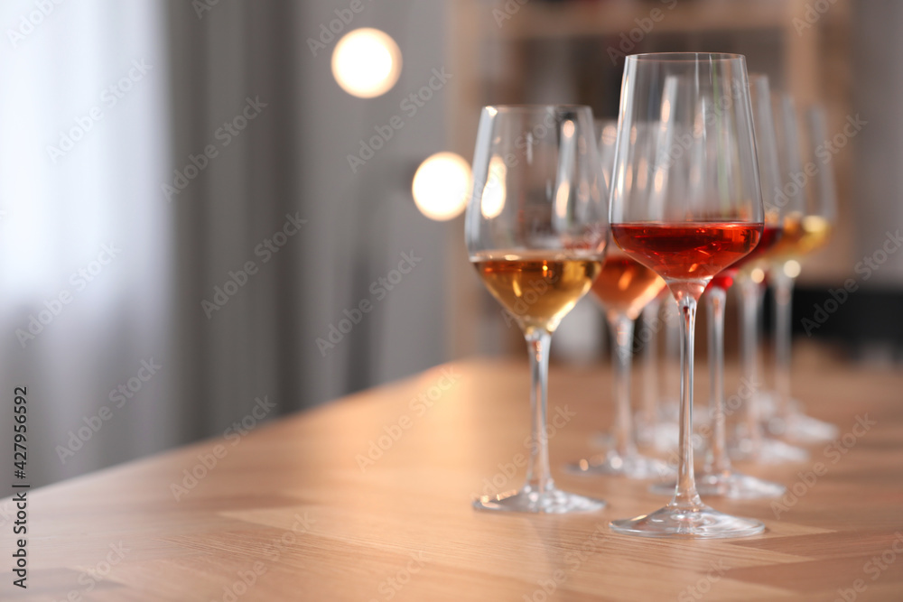 Different sorts of wine in glasses on wooden table indoors. Space for text Different sorts of wine in glasses on wooden table indoors. Space for text