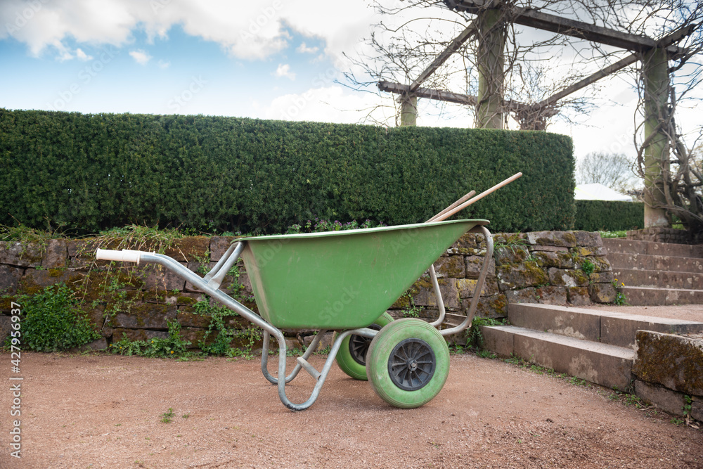 schubkarre und gartengerät im park gartenarbeit für gärtner
