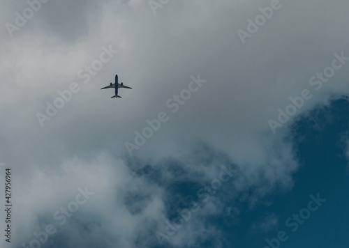 Avión volando a través de las nubes visto desde abajo photo