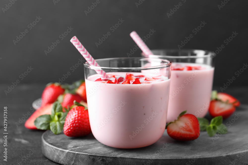Delicious drink with strawberries on black table Delicious drink with strawberries on black table