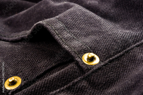 clothing items stonewashed cotton fabric texture with seams, clasps, buttons and rivets, macro