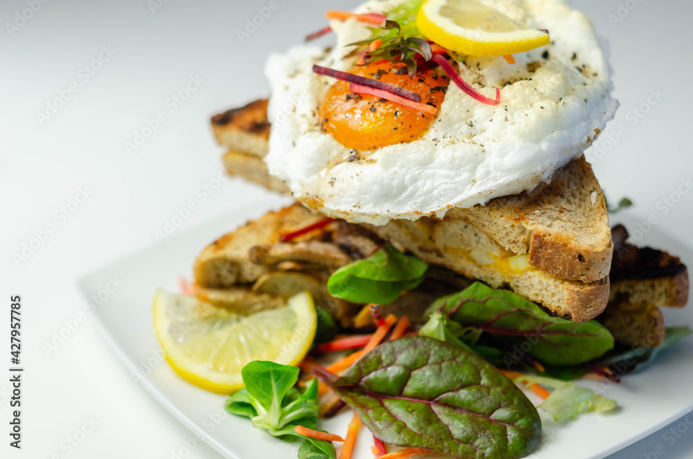 Egg in a cloud on grilled sandwiches with cumberland sausage, tomato and mayonnaise, all served with a fresh salad Egg in a cloud on grilled sandwiches with cumberland sausage, tomato and mayonnaise, all served with a fresh salad