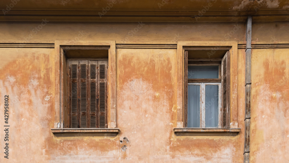 Old fashioned wooden windows, on grunge wall background.