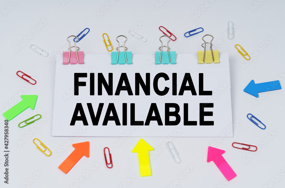 On the table there are paper clips and directional arrows, a sign that says - Financial Available On the table there are paper clips and directional arrows, a sign that says - Financial Available