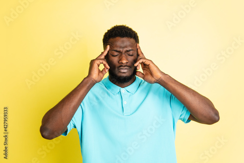 Portrait of young African man isolated over yellow studio background with copyspace. © master1305