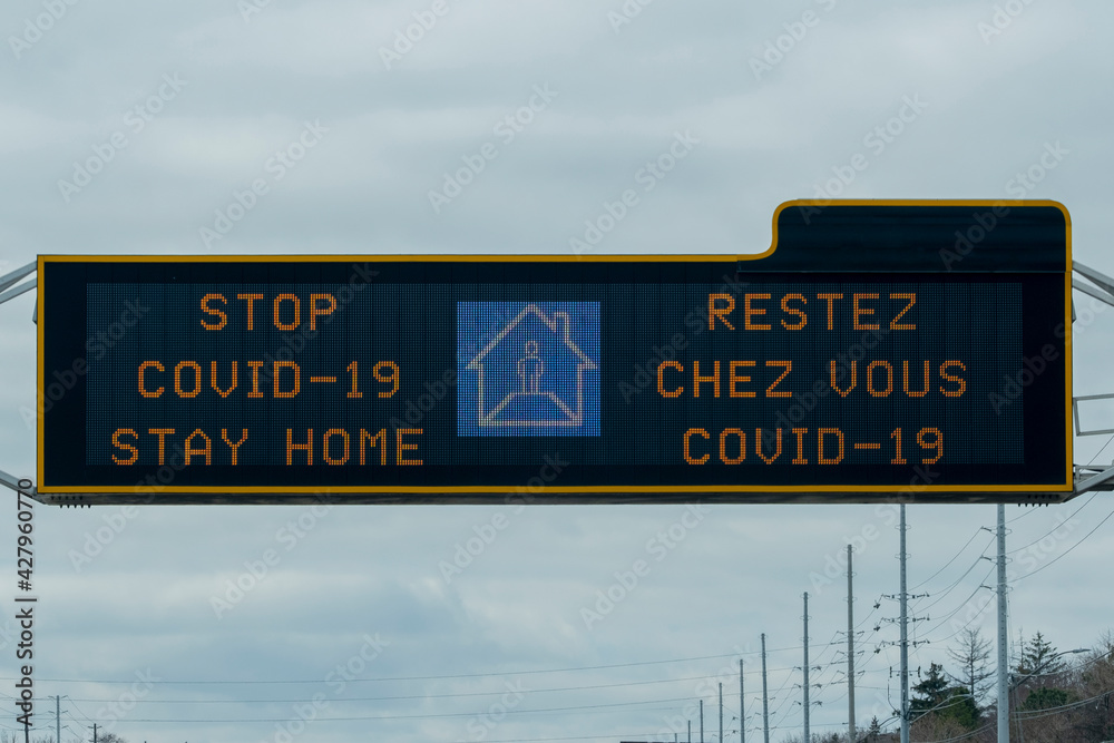 Sign stop covid-19 stay home on a scoreboard over highway during corona virus covid 19 pandemic outbreak quarantine lockdown. Selective focus.