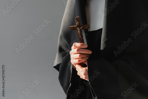 Fotografia cropped view of nun holding crucifix isolated on grey