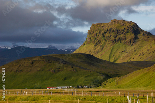 Green mountainscape with farm and fields close to Hringvegur/Route 1 near Vík í Mýrdal, Iceland