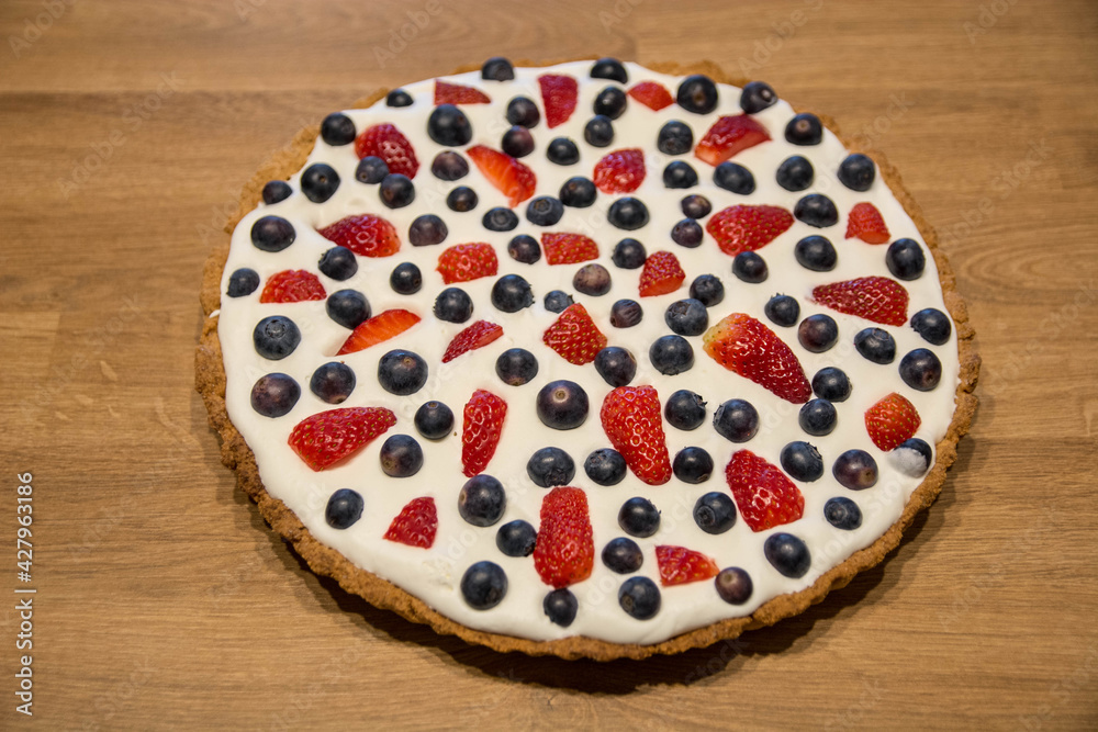 Tarta na kruchym cieście z bitą śmietaną i owocami - truskawkami i borówkami
