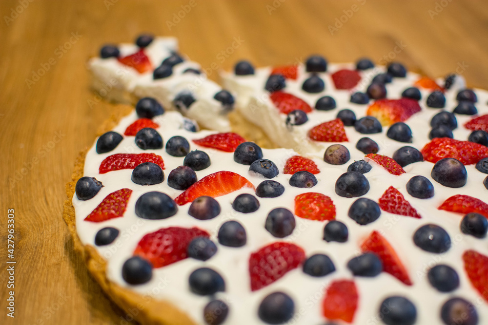 Tarta na kruchym cieście z bitą śmietaną i owocami - truskawkami i borówkami