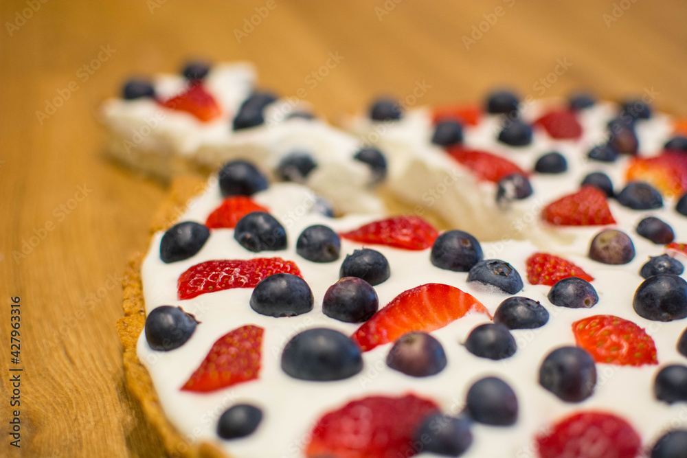 Tarta na kruchym cieście z bitą śmietaną i owocami - truskawkami i borówkami