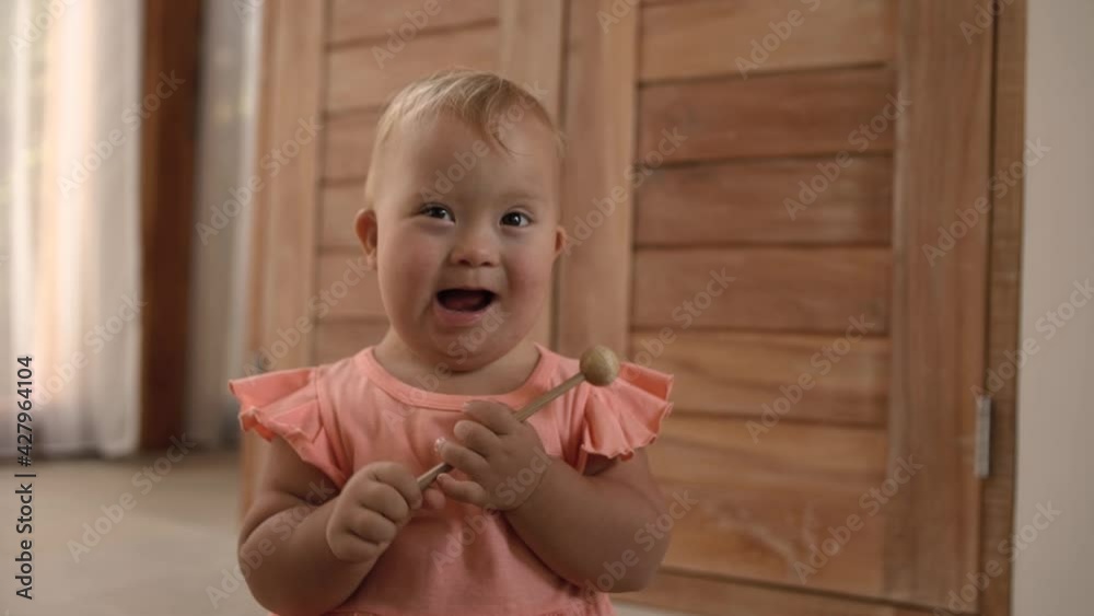 Happy baby girl down syndrome play have fun with her family at home. hild hits a xylophone with a stick. Happy baby girl down syndrome play have fun with her family at home. hild hits a xylophone with a stick.