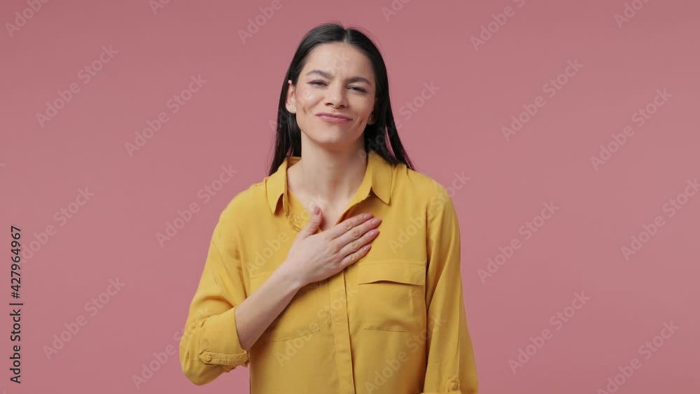 Excited confident brunette young latin woman 20s years old in casual yellow shirt posing isolated on pastel pink background studio. People lifestyle concept. Pointing thumbs index fingers on herself Excited confident brunette young latin woman 20s years old in casual yellow shirt posing isolated on pastel pink background studio. People lifestyle concept. Pointing thumbs index fingers on herself