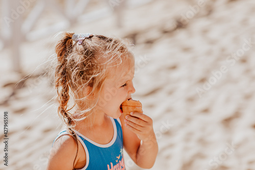 Girl eating the ice cream on the beach. Summertime. Copy space.