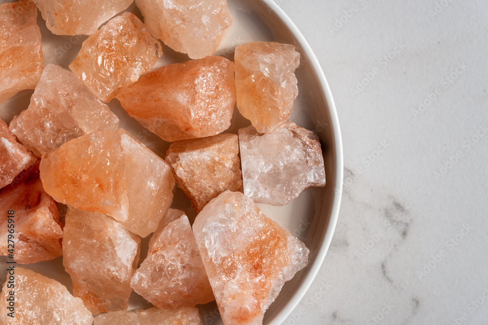 Organic Himalayan mineral salt crystals on round ceramic tray. Interior decoration and spa ingredient for wellness procedures Organic Himalayan mineral salt crystals on round ceramic tray. Interior decoration and spa ingredient for wellness procedures