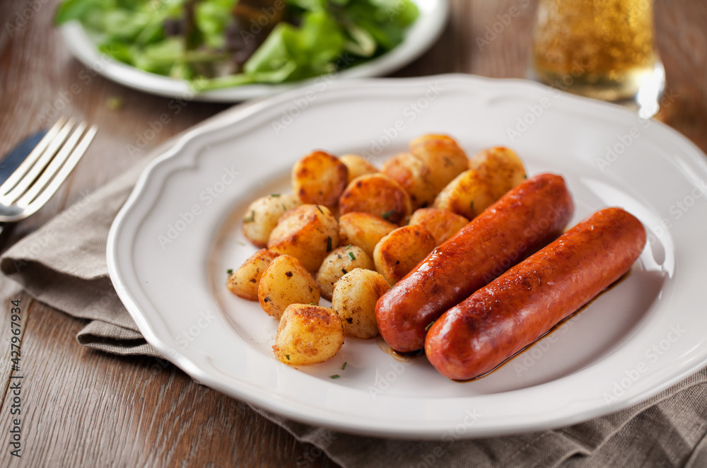 Sausages and potatoes on a plate. High quality photo.