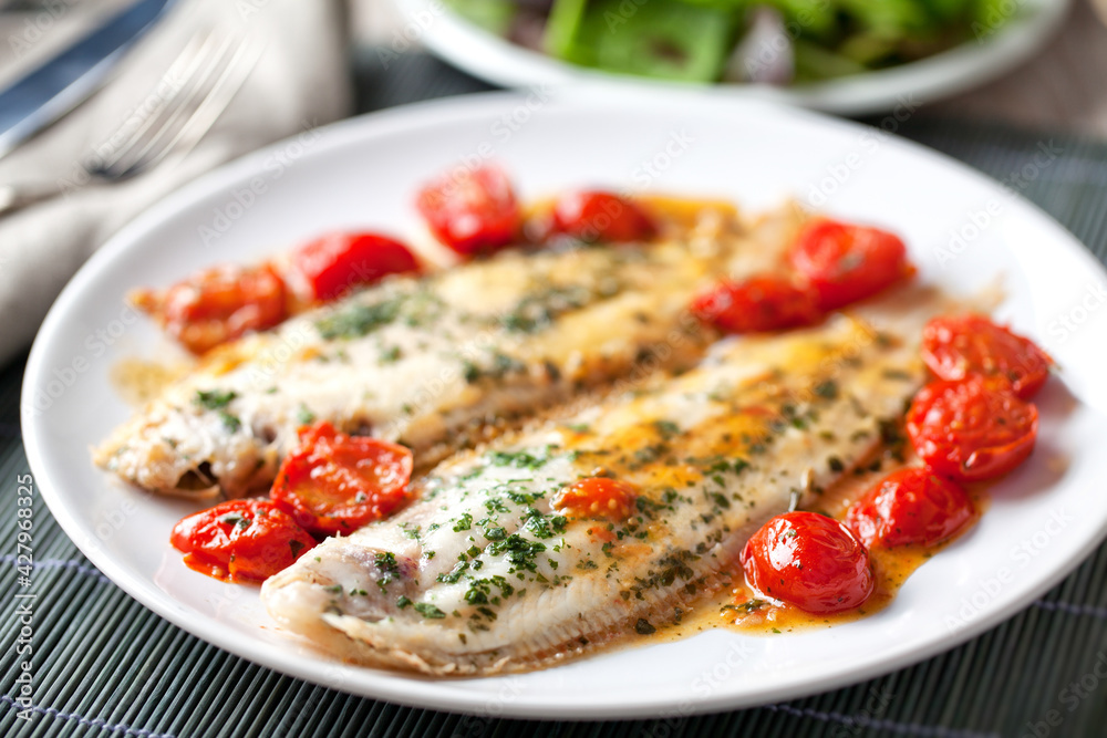 Sole with cherry tomatoes on a plate. High quality photo. Sole with cherry tomatoes on a plate. High quality photo.