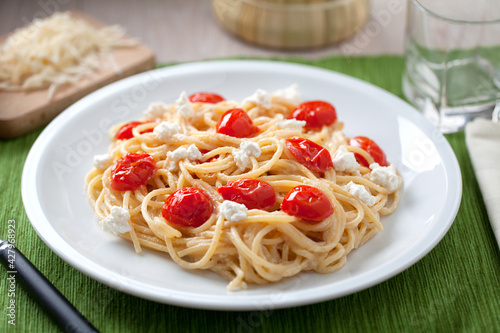 Spaghetti with cherry tomatoes and fresh ricotta on a plate.