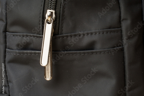 zipper on black material fabric. close-up of a snake fastener