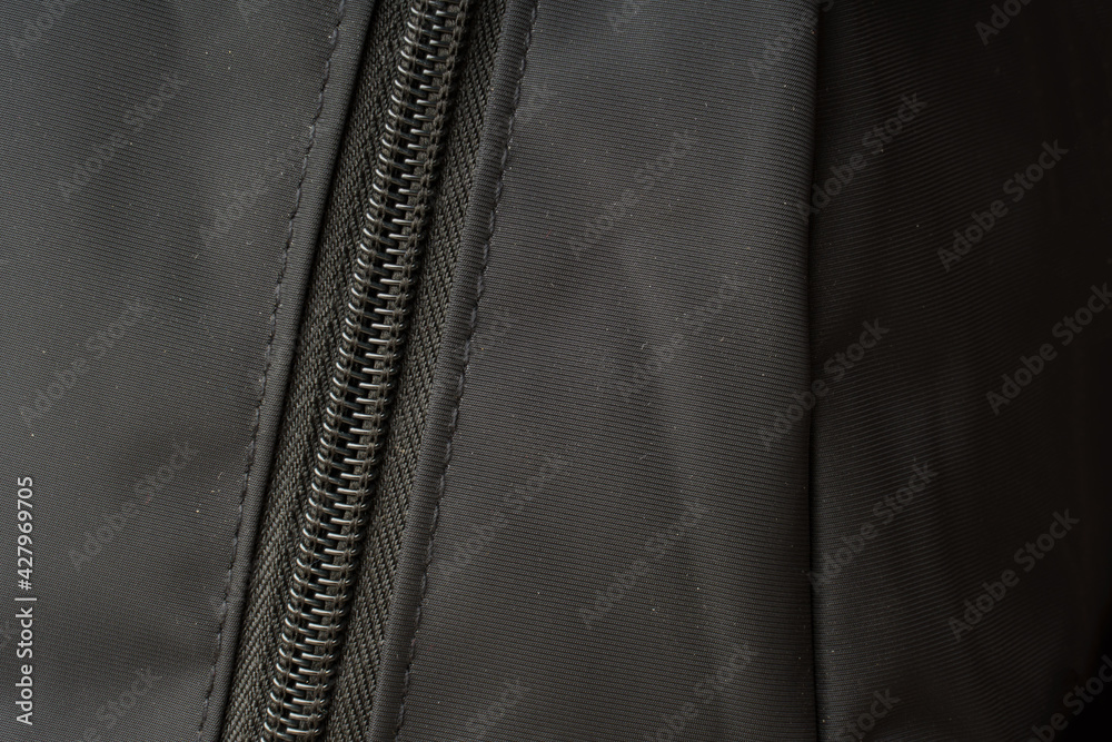zipper on black material fabric. close-up of a snake fastener zipper on black material fabric. close-up of a snake fastener