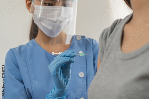 Covid-19, coronavirus hand of young woman doctor or nurse giving syringe vaccine, inject shot to arm patient. Vaccination, immunization or disease prevention against flu or virus pandemic concept.