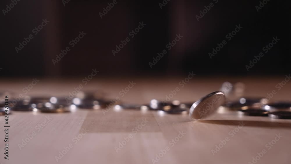 the coin is spinning on the table among the coins the coin is spinning on the table among the coins